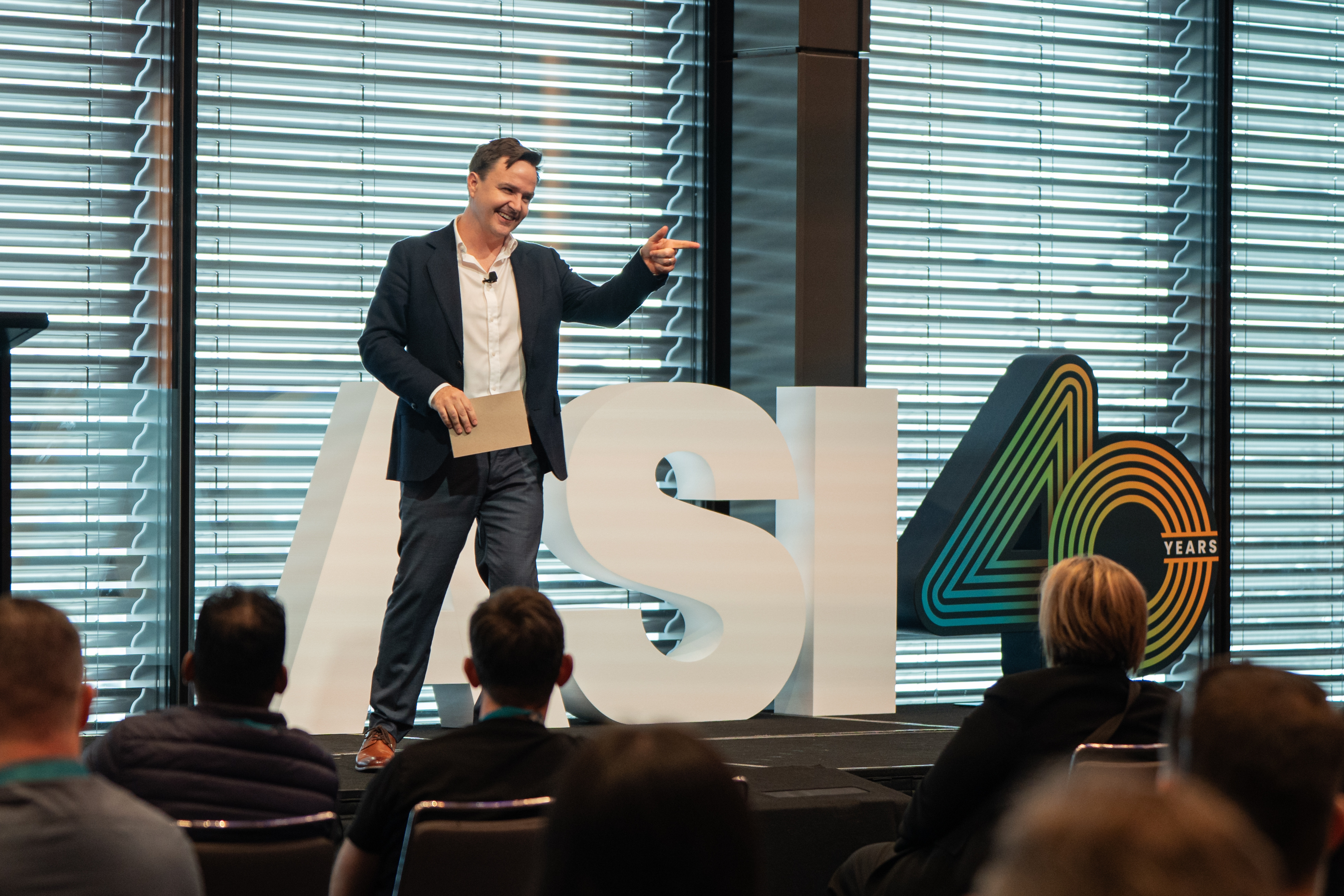 Shaun Kenny presenting on stage at a conference