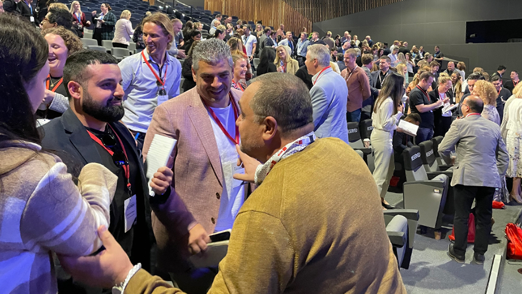 Delegates networking in the auditorium after a leadership conference