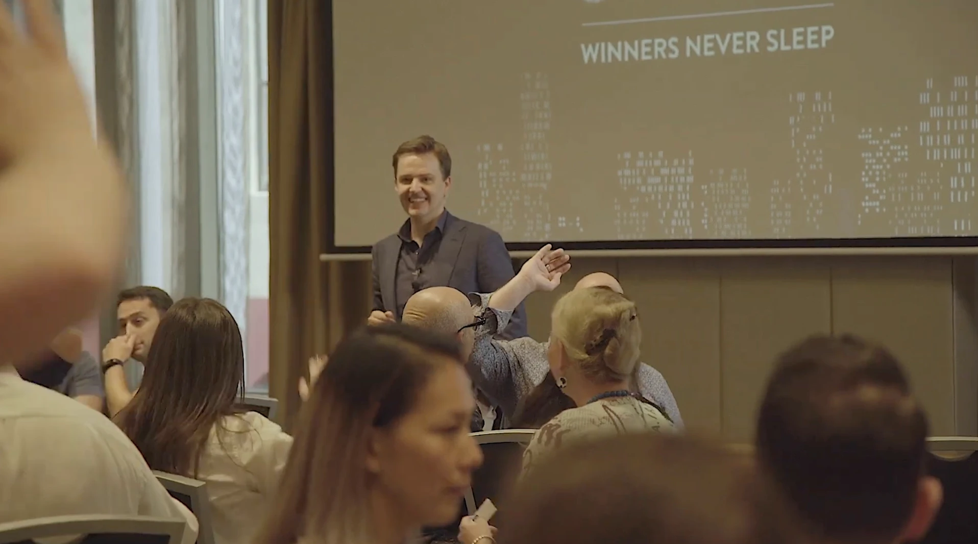 The facilitator debriefing the room under the Winners Never Sleep slide
